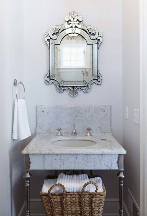 miroir venitien au dessus d'une vasque en marbre dans salle de bains italienne