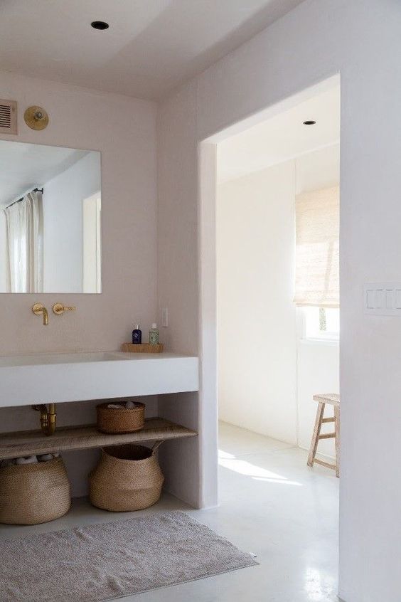 paniers à linge en osier dans une salle de bains minimaliste slow design