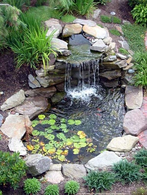 mini cascade dans un bassin d'eau décoré de pierres en granite