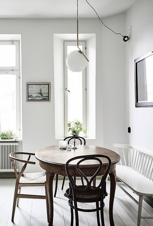 banquette en bois blanc et chaises scandinaves autour d'une table rustique
