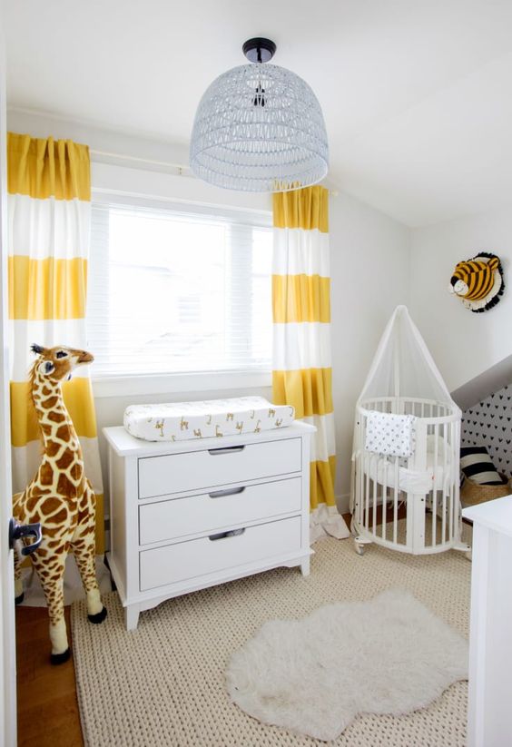 chambre bébé avec animaux en peluche et abat-jour de couleur pastel suspendu au plafond