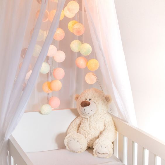 luminaire chambre bébé en guirlande couleur pastel accrochée au dessus du lit