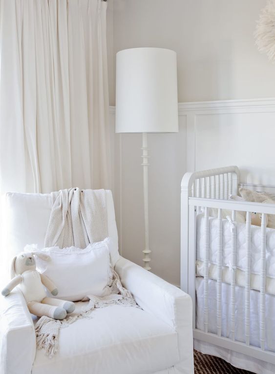 lampadaire blanc pour éclairer le fauteuil d'allaitement dans une chambre bébé blanche