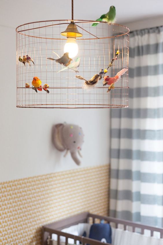 oiseaux en peluche accrochés à la suspension en fer dans une chambre bébé