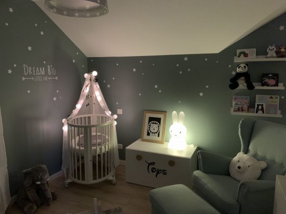 luminaire chambre bébé doux avec veilleuse sous forme de lapin sur la commode et des guirlandes lumineuses au dessus du lit