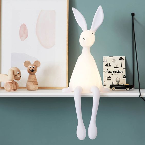 veilleuse pour bébé sous forme de lapin posée sur une étagère en bois