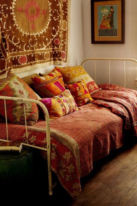coussins de couleurs vives et tissus chamarrés sur un lit en fer pour une déco indienne