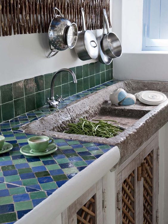 cuisine méditerranéenne avec plan de travail en carreaux zellige verts et bleus et évier en pierre