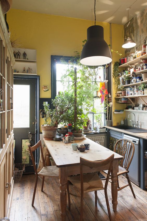 table de cuisine rectangulaire rustique dans une cuisine méditerranéenne avec ustensiles apparents sur étagères en bois