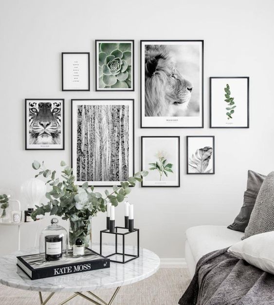 photos d'animaux et de plantes dans des cadres modernes noirs accrochés au mur d'un salon scandinave gris et blanc