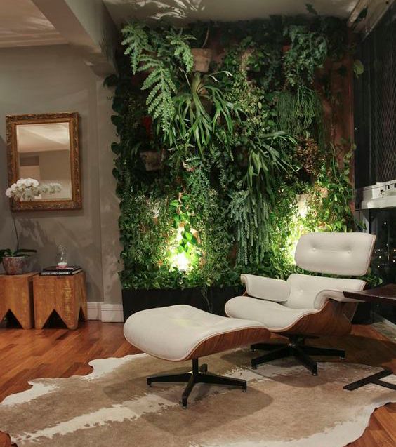 mur végétal de plantes vertes au dessus d'un fauteuil relaxant dans un salon moderne