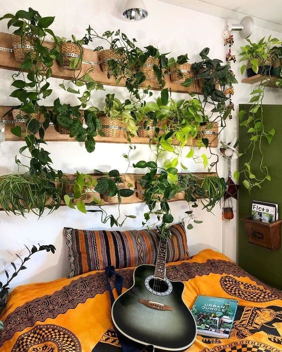déco murale naturelle avec pots de plantes vertes au dessus d'un lit au linge bohème