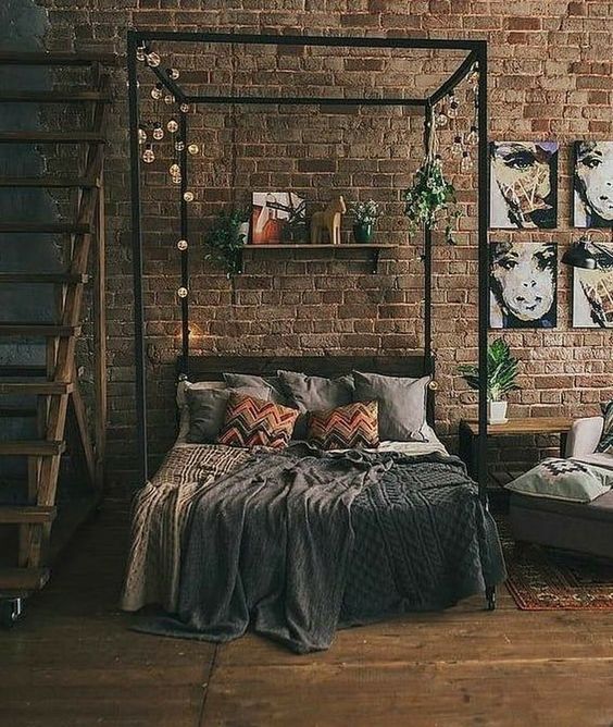 déco urbaine pour la chambre adulte avec mur en briques rouges et linge de lit de couleurs foncés