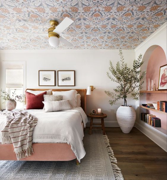 papier peint fleuri au plafond d'une chambre à déco romantique avec peinture rose au mur et draps blancs cosy