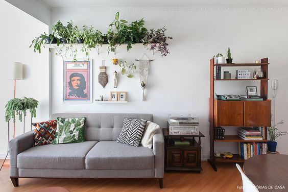 déco murale salon avec des cadres mélangés à des plantes vertes sur une étagère