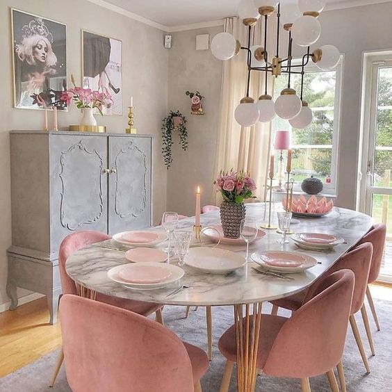 déco romantique shabby dans une salle à manger avec chaises roses en velours autour d'une table en marbre blanc