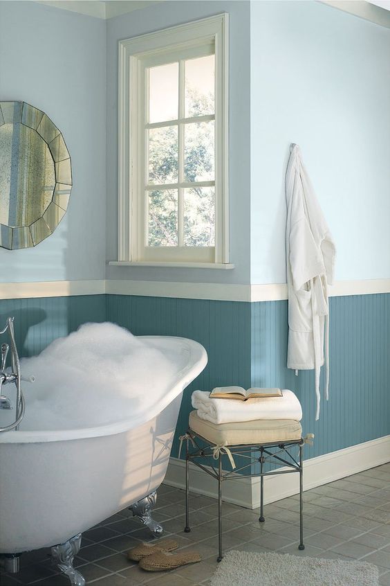 nuances de bleu sur les murs d'une salle de bains avec baignoire blanche en céramique