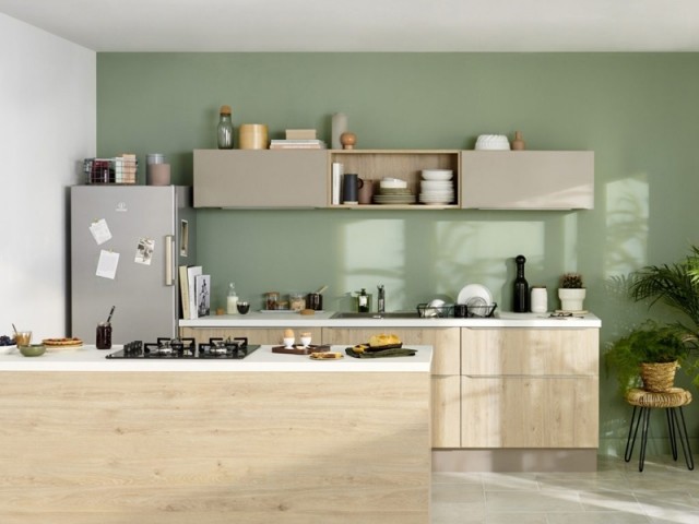 Une cuisine naturelle avec un mur vert amande
