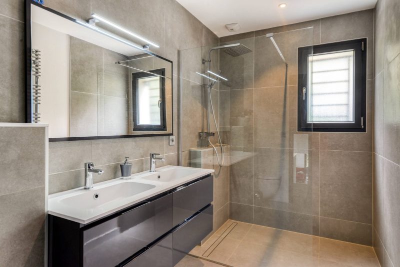 Une grande douche à l'italienne dans une salle d'eau à la déco moderne