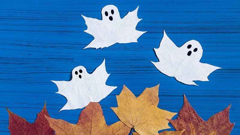 Trois fantômes en feuilles d'érable, peints en blanc avec des visages