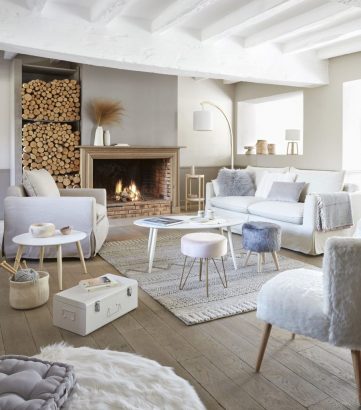 Un aménagement cheminée est très lumineux, avec le vaste salon ponctué de meubles en bois dans les tons beiges et blancs