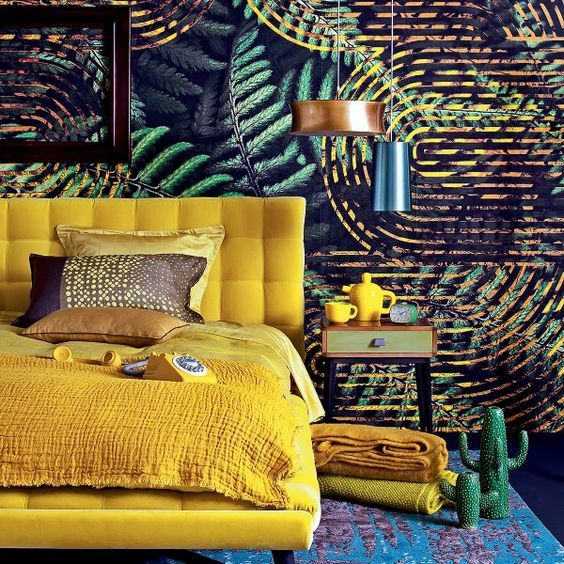 Chambre tropicale avec un grand lit jaune vif et des murs aux motifs tropicaux