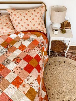 Un lit deux places vu du dessus, avec un édredon patchwork fleuri