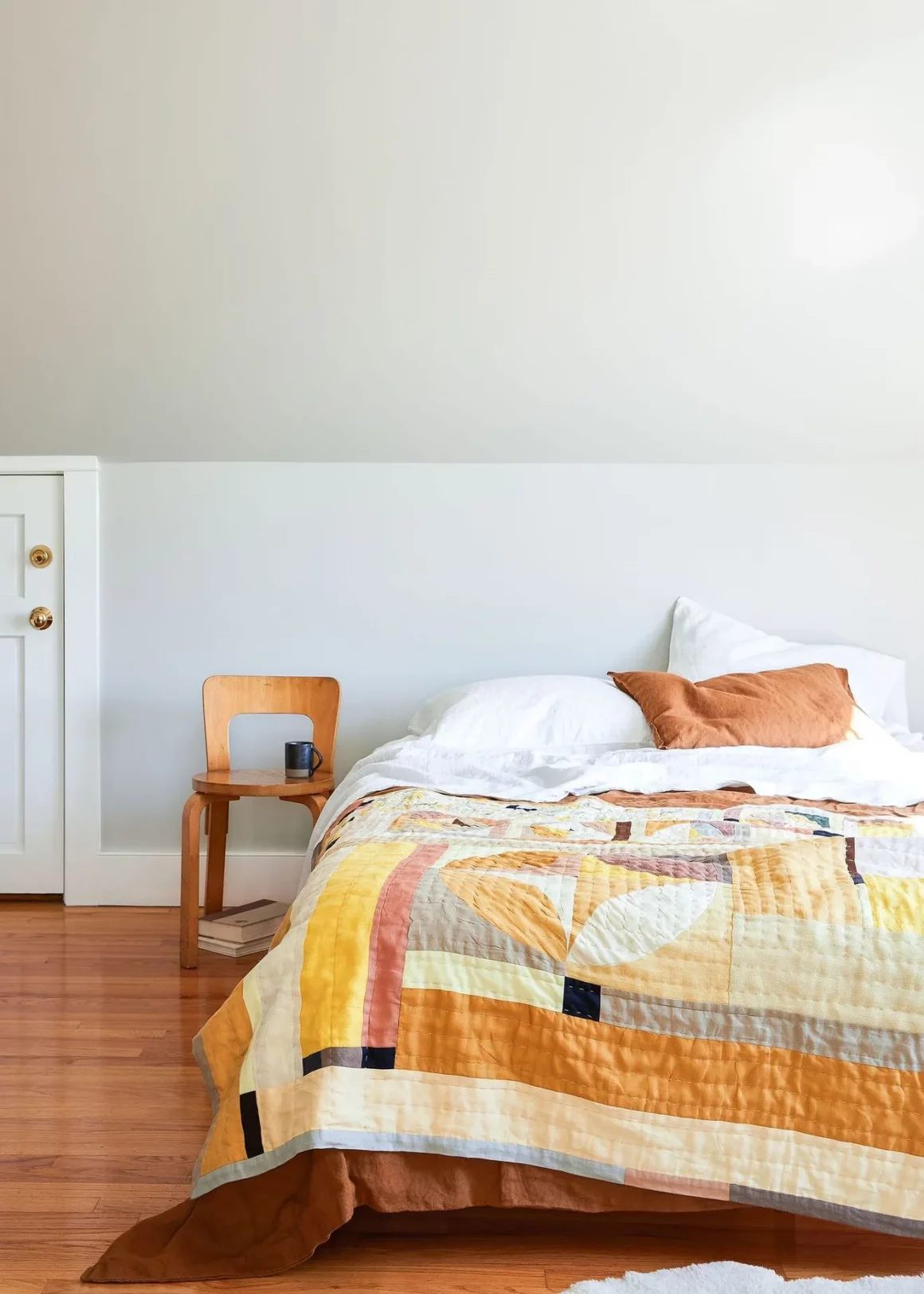 Un édrdeon en patchwork sur un lit deux places, dans les tons orange et jaunes