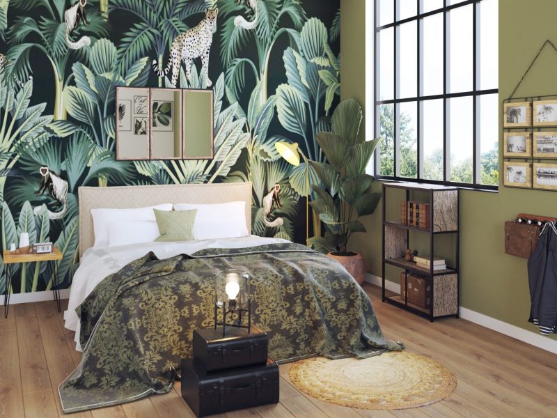 Le lit deux places se pare de draps aux motifs végétaux, avec un sol en parquet et du papier peint tropical au-dessus de la tête de lit
