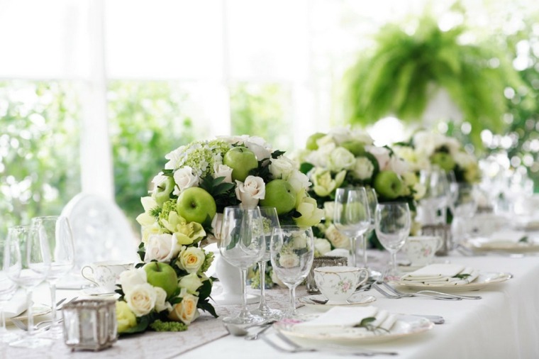 Des bouquets de roses blanches, très sophistiqués, à côté d'élégants verres en verre