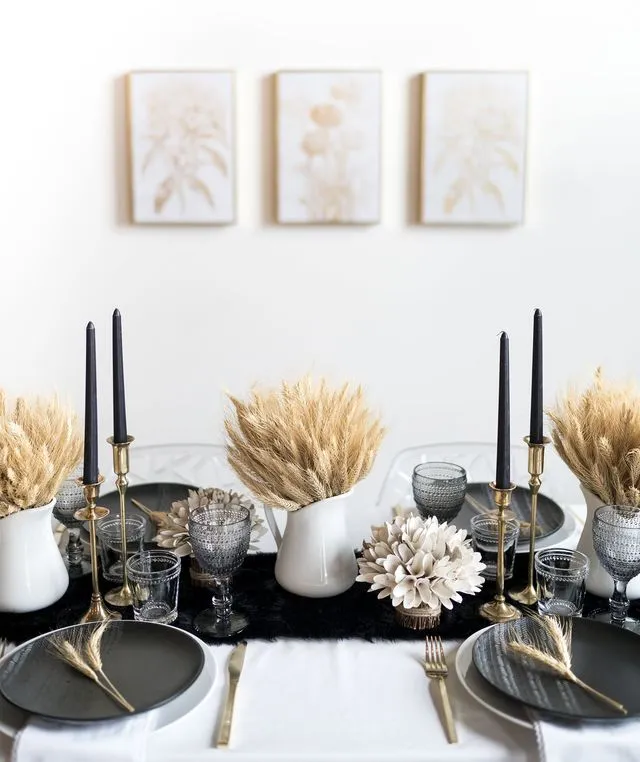 décoration table jour de l'an avec chandeliers noirs au dessus d'une nappe blanche