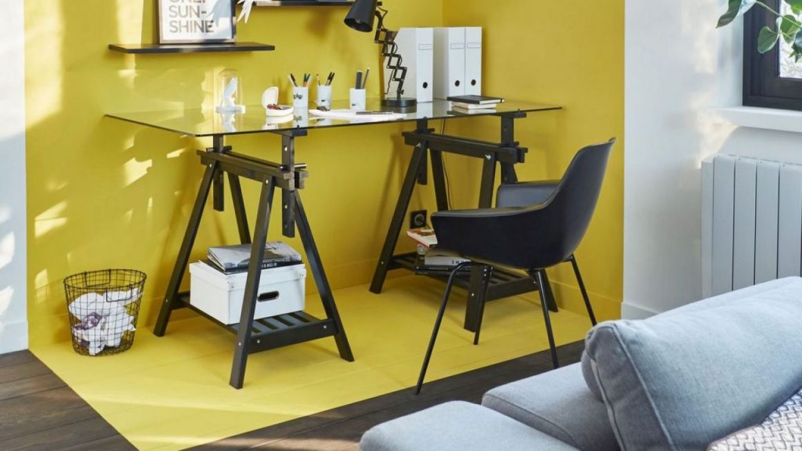 Idéale pour aménager un espace ouvert, la peinture jaune vient délimiter un coin bureau dans le salon