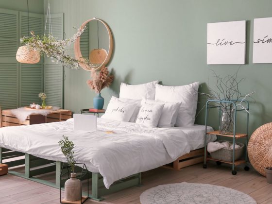 Une déco chambre tendance avec des murs vert amande, un lit blanc et des accessoires en osier