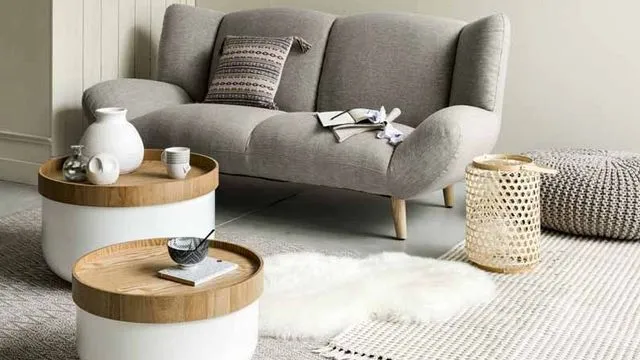 Ambiance scandinave dans ce salon, avec un canapé gris clair et deux tables basses qui peuvent servir de rangements.