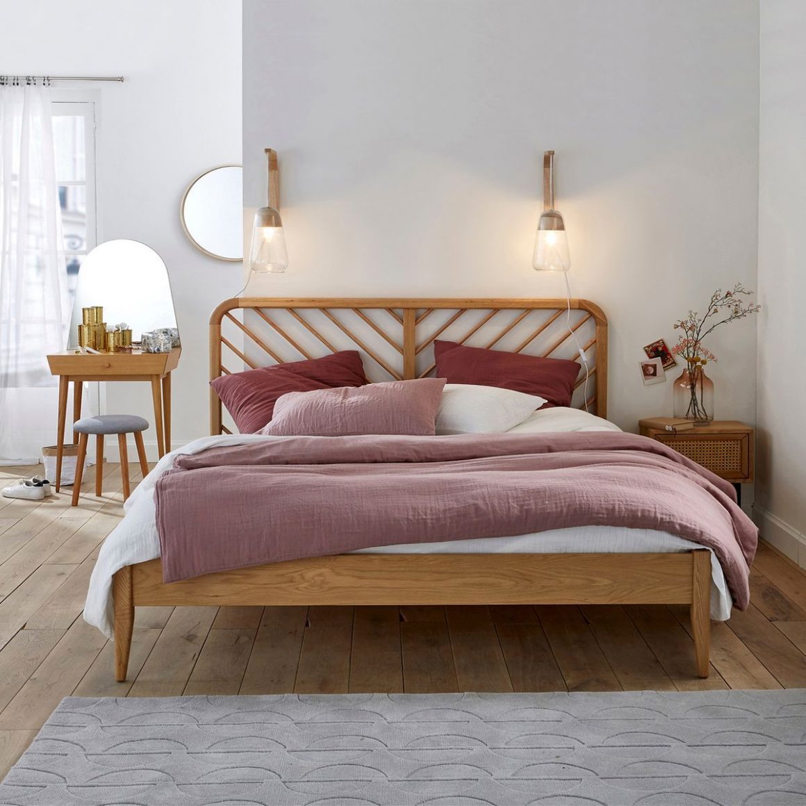 La déco chambre tendance se compose d'un lit double de style scandinave, avec une tête de lit en rotin