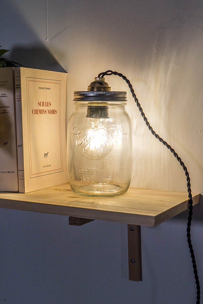 Un luminaire DIY dans un bocal en verre, posé sur une étagère