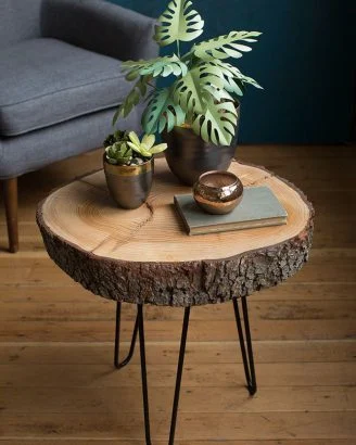 Une petite table d'appoint, faite avec un fin rondin monté sur des pieds en métal