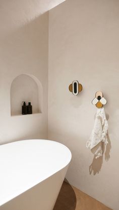 Cette salle de bains design est très simple, avec des porte-serviettes accrochés au mur