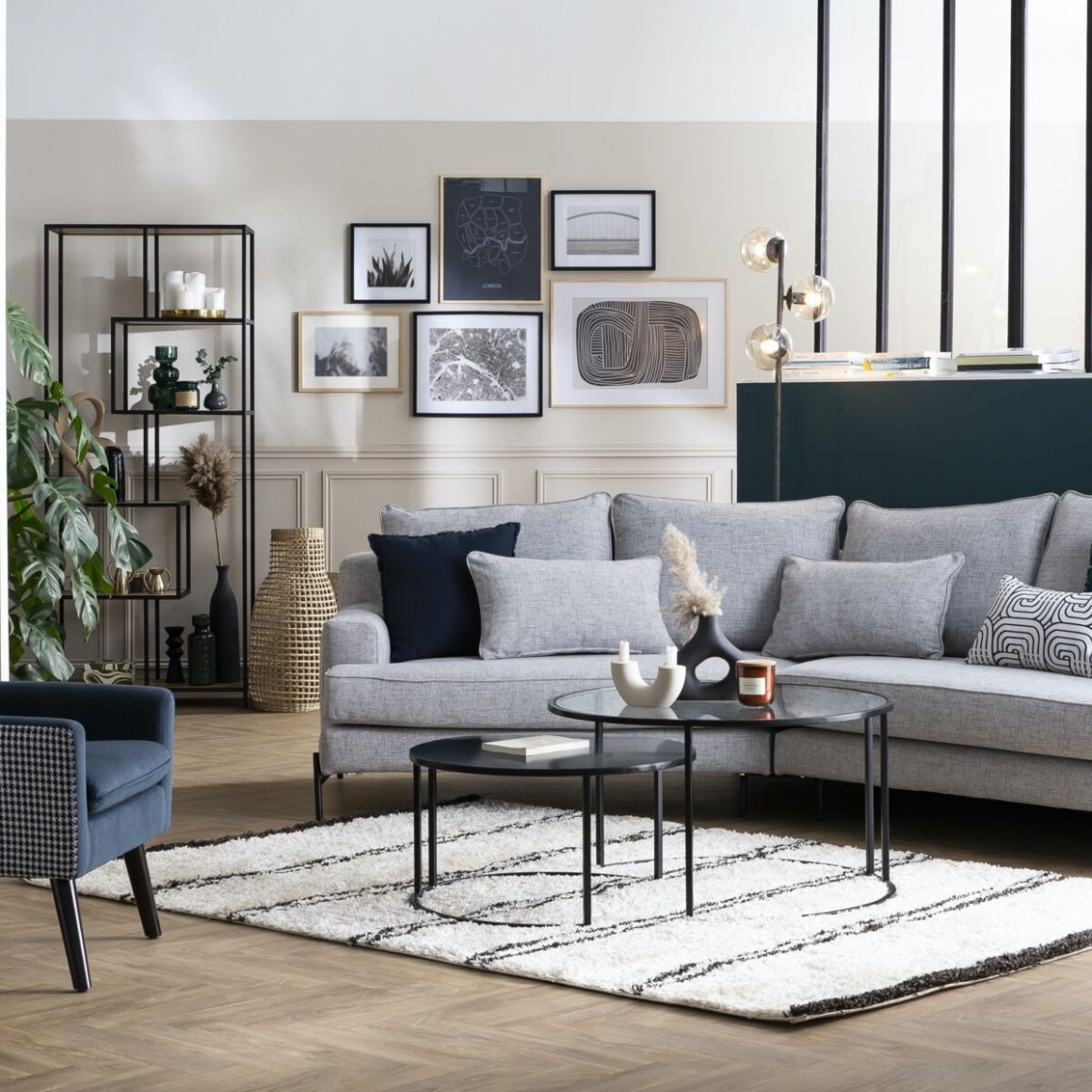 Une déco maison de charme avec du mobilier moderne dans une pièce à l'authentique cachet : parquet à chevrons, table basse moderne, canapé gris