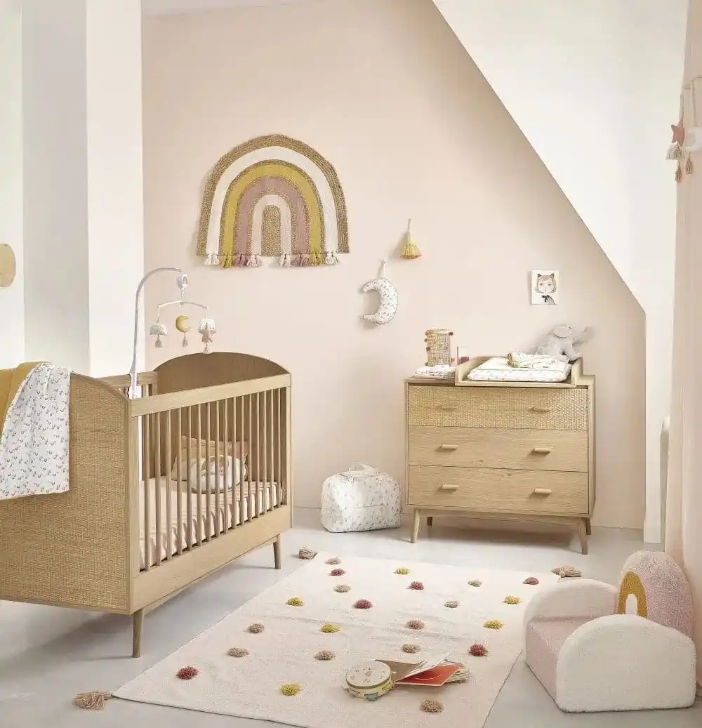 Chambre de bébé dans les tons clairs, avec du mobilier en bois, de style scandinave