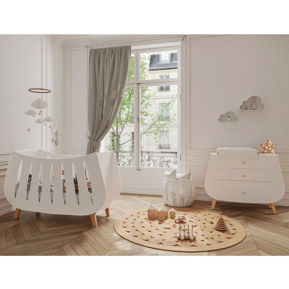 Chambre de nouveau-né décorée dans le style scandinave, avec des meubles blancs, avec des pieds en bois clair