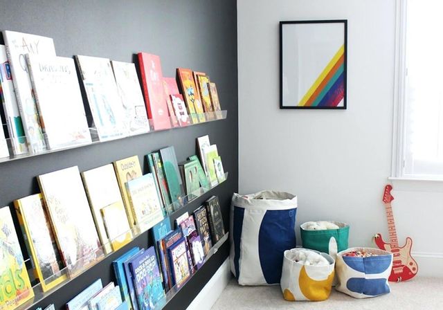 Une chambre d'enfant avec des étagères permettent de ranger des livres avec la couverture de face