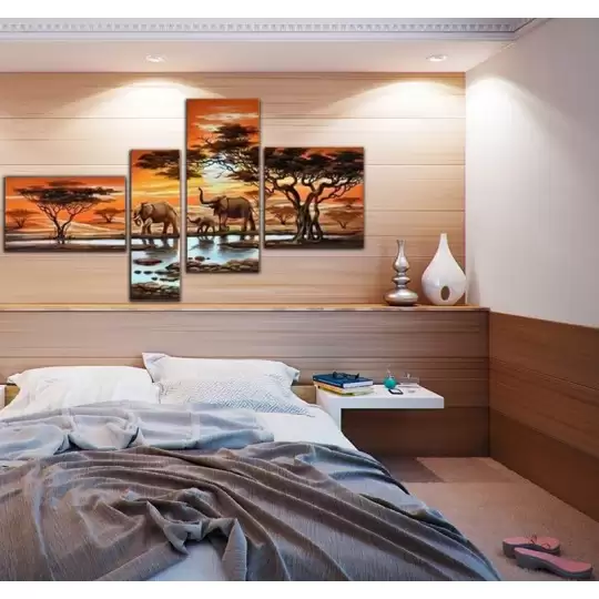 Au-dessus du lit de la chambre à coucher, une composition de plusieurs tableaux met en valeur un coucher de soleil africain