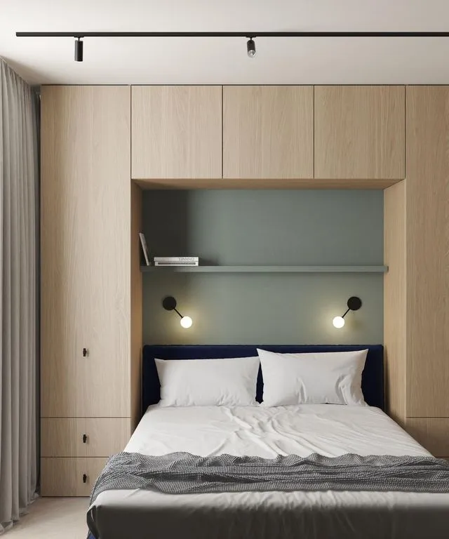 Le lit double est encastré entre des placards, sur les côtés et au-dessus