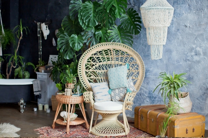 Un fauteuil en osier devant une plante verte tropicale, avec une petite table basse