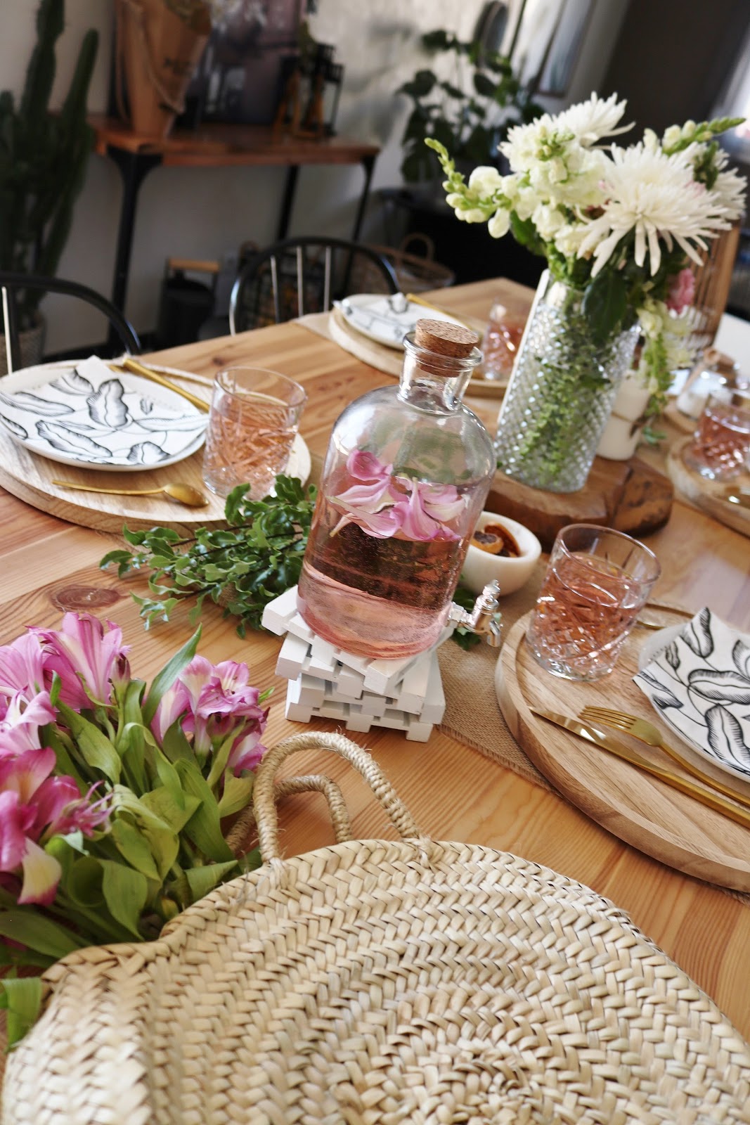 Cette table d'été arbore des couleurs douces et pastel, avec des fleurs et des matières naturelles