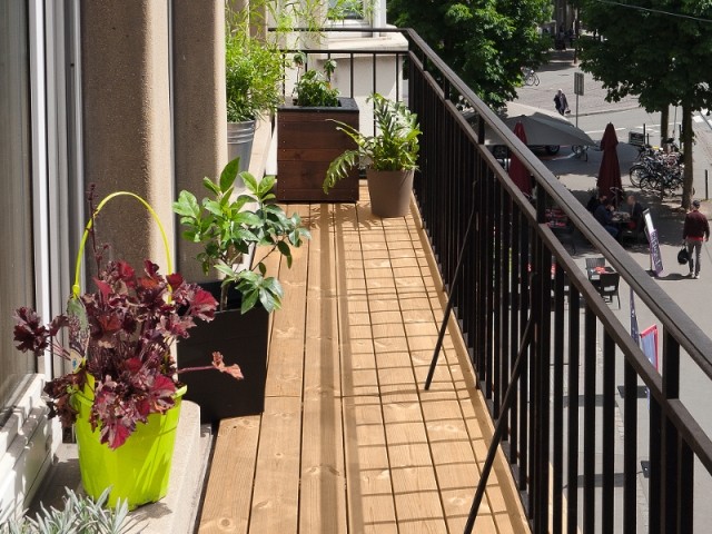 Ce balcon tout en longueur s'orne de lames de terrasse en bois