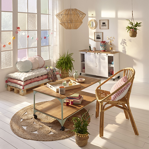 Salon de style scandicraft, avec des matières naturelles : une chaise en osier, un abat-jour en rotin et une table en bois