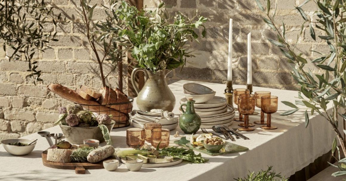 La vaisselle utilisée arbore des couleurs terreuses, et les assiettes, les bougeoirs, les verres et les pots à eau sont en matériaux naturels
