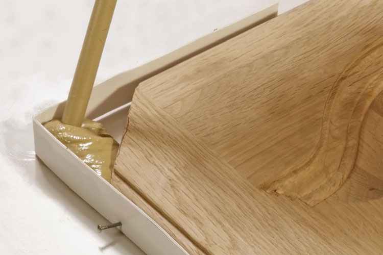 Utilisation de pâte à bois pour réparer le coin de la porte d'une commode